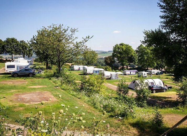 Camping site Comfort in Gulpen, South Limburg offers a beautiful view over green fields and caravans in a quiet nature campsite.
