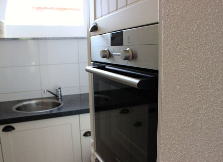 Gezellige woonkamer in Vakantiehuisje in Gulpen, Zuid Limburg, met bloemen en zitgedeelte.