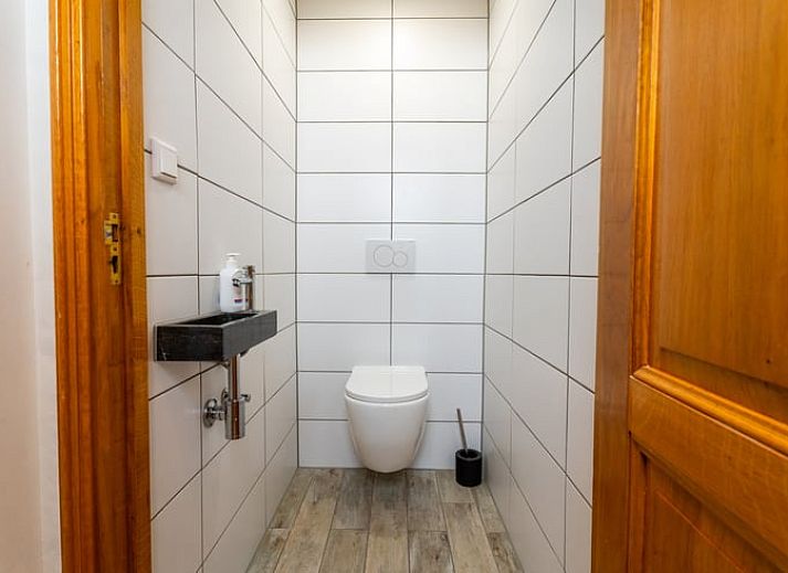 Stylish living room of Holiday home in Klimmen, South Limburg, with wooden floor and modern interior.