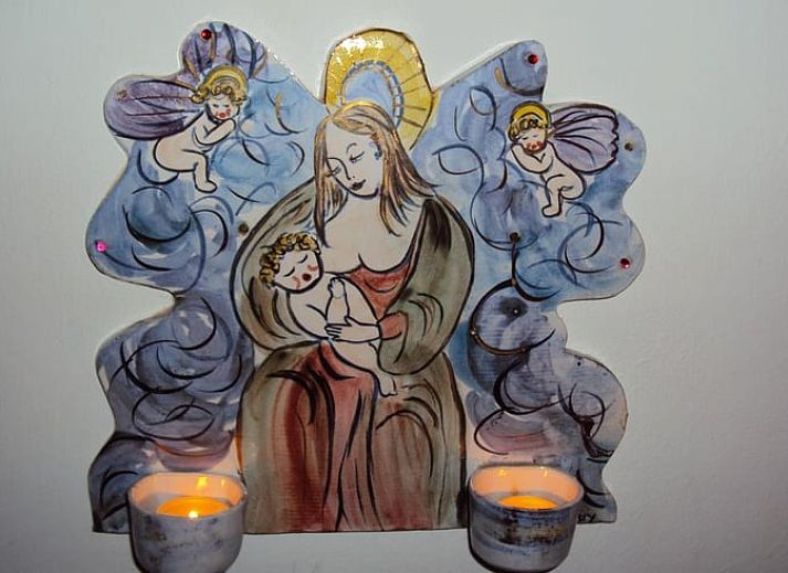 Red front door of Holiday home in Epen, South Limburg, surrounded by green bushes.