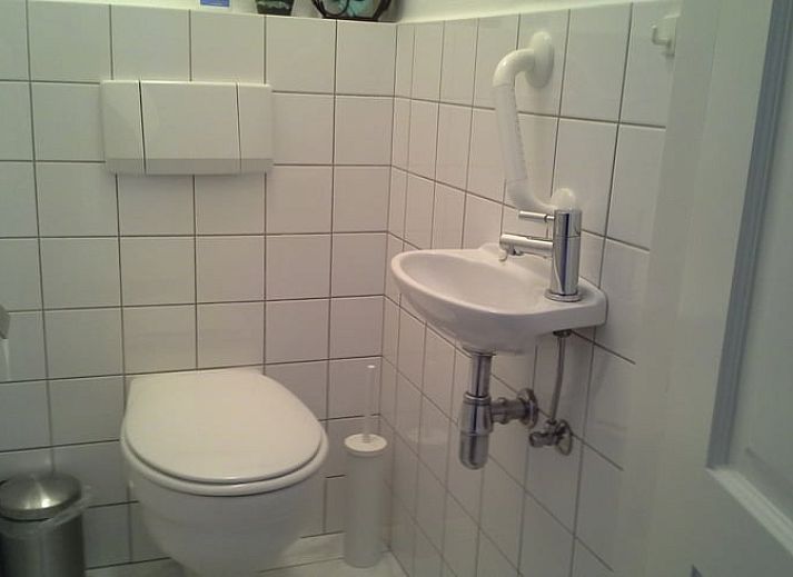 Modern kitchen in Cottage in Epen, South Limburg, vacation home with sleek white cabinets and garden views.