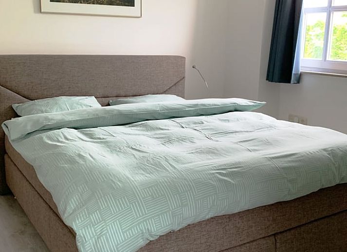 Modern kitchen in Cottage in Epen, South Limburg, vacation home with sleek white cabinets and garden views.