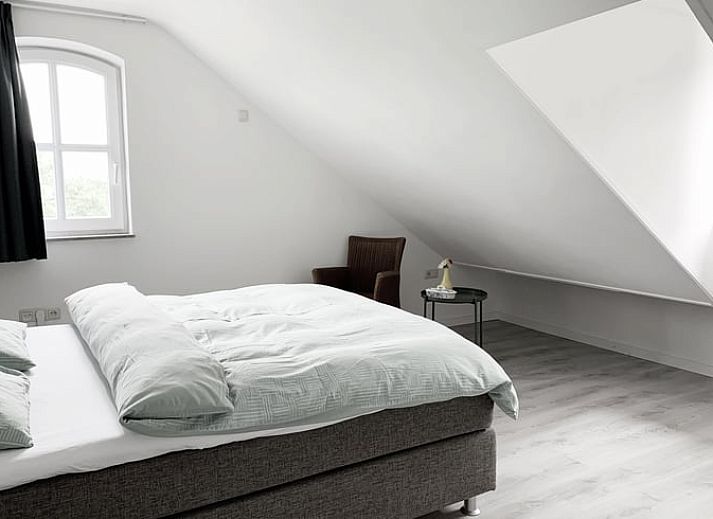 Modern kitchen in Cottage in Epen, South Limburg, vacation home with sleek white cabinets and garden views.