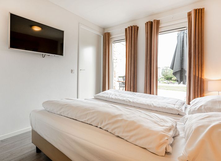 Zwembad met ligstoelen bij Vakantiehuis Green Resort Mooi Bemelen in Limburg.