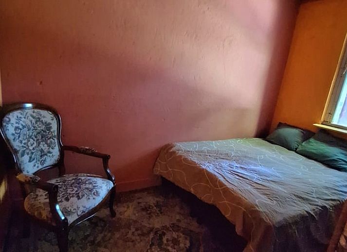 Gezellige woonkamer in Vakantiehuis in Heerlen, Zuid Limburg met comfortabele bank en houten plafond.