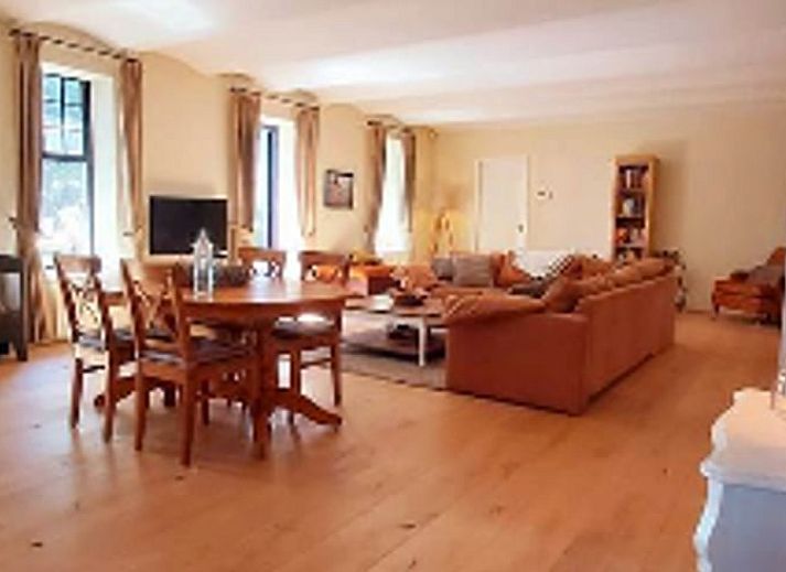 Gemuetlicher Eingang zum Ferienhaus in Beek, Suedlimburg, umgeben von bluehenden Blumen und rustikalem Charme.