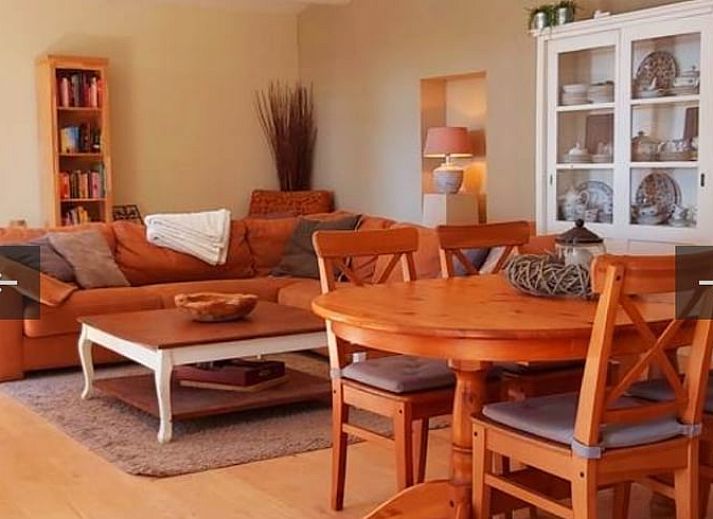 Gemuetlicher Eingang zum Ferienhaus in Beek, Suedlimburg, umgeben von bluehenden Blumen und rustikalem Charme.