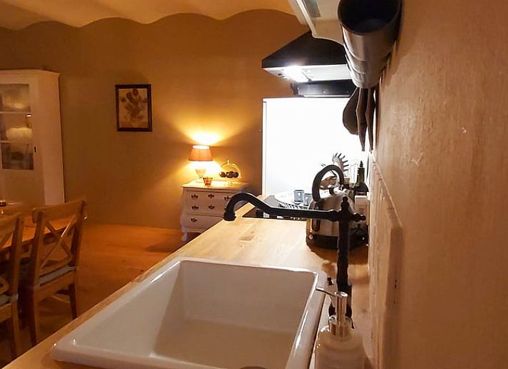 Gemuetlicher Eingang zum Ferienhaus in Beek, Suedlimburg, umgeben von bluehenden Blumen und rustikalem Charme.