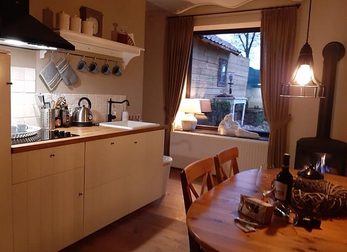 Gemuetlicher Eingang zum Ferienhaus in Beek, Suedlimburg, umgeben von bluehenden Blumen und rustikalem Charme.