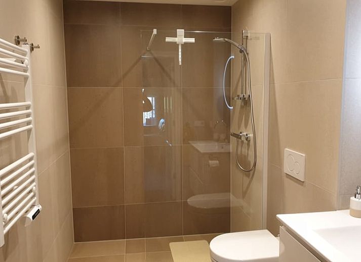 Ontspan in de tuin van Huisje in Valkenburg aan de Geul, vakantiewoning in Limburg met ligstoelen en parasol.