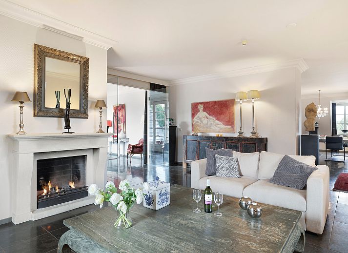 Elegant interior of Kasteeldomein De Cauberg penthouse in Valkenburg, South Limburg with stylish dining room and fireplace.