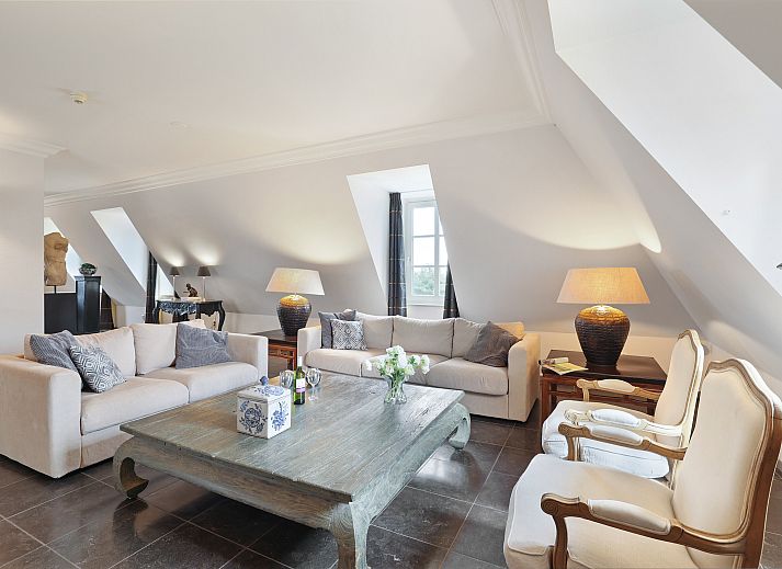 Elegant interior of Kasteeldomein De Cauberg penthouse in Valkenburg, South Limburg with stylish dining room and fireplace.