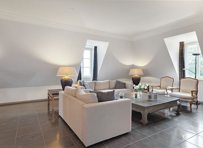 Elegant interior of Kasteeldomein De Cauberg penthouse in Valkenburg, South Limburg with stylish dining room and fireplace.