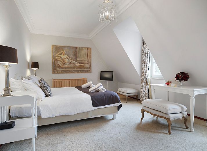 Luxury interior of Kasteeldomein De Cauberg penthouse in Valkenburg, South Limburg, with elegant living room and cozy fireplace.