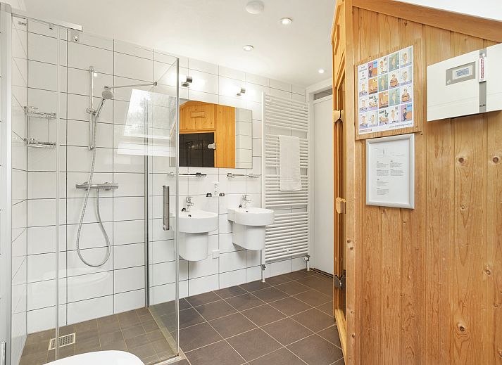 Dining area in Hoog Vaals bungalow 8L2, Vaals, with modern kitchen and large dining table.