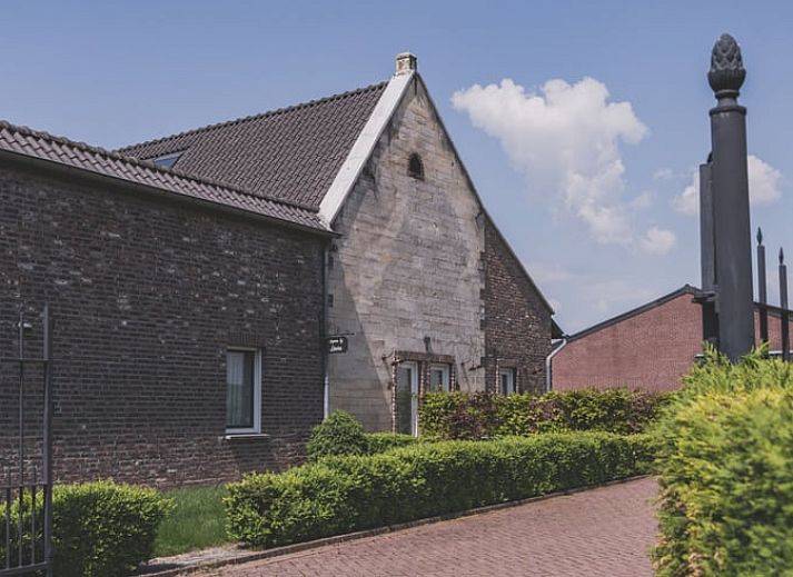 Vakantiehuis in Scheulder, Zuid Limburg, met charmante stenen gevel en groene heg.