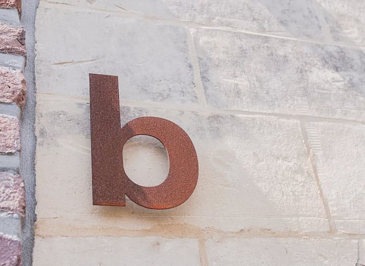 Vakantiehuisje in Scheulder, Zuid Limburg, met charmante stenen gevel en fietsers op de voorgrond.
