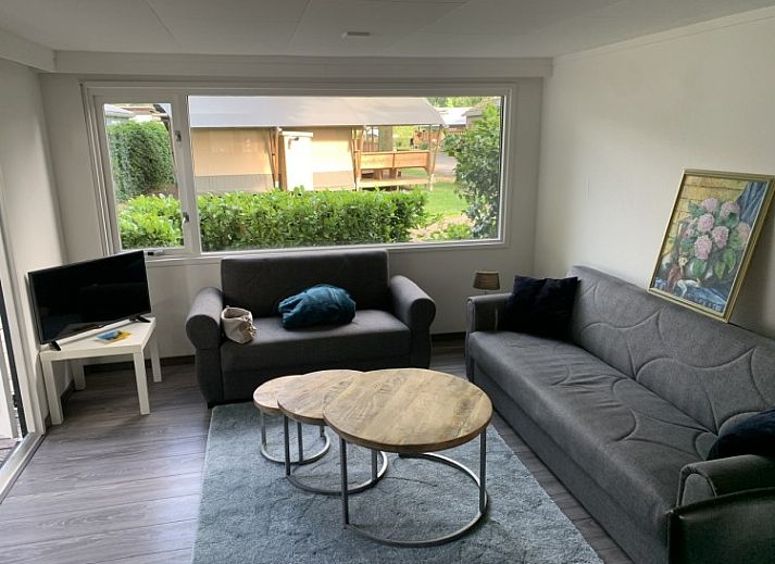 Buitenkant van Stacaravan Joopie in Schimmert, Zuid Limburg met veranda en groene omgeving.