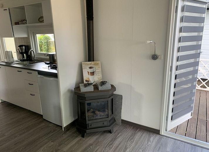 Buitenkant van Stacaravan Joopie in Schimmert, Zuid Limburg met veranda en groene omgeving.