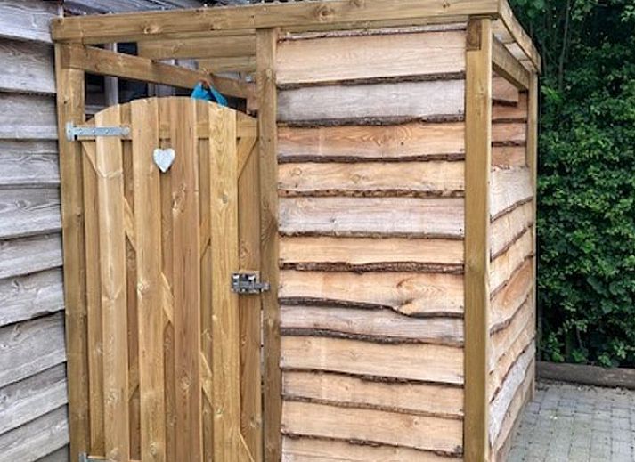View of green meadows from Holiday home in Nuth, South Limburg, with charming sitting area.