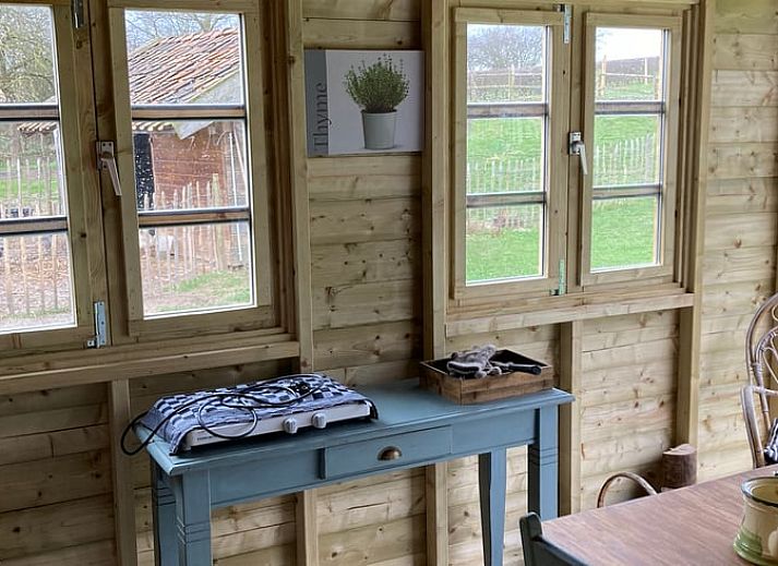 View of green meadows from Holiday home in Nuth, South Limburg, with charming sitting area.