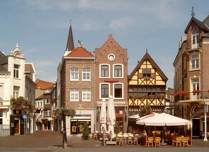 Stijlvolle zitruimte in L173 vakantiehuis, Sittard, Zuid Limburg, met rustieke houten muren en bloemendecoratie.