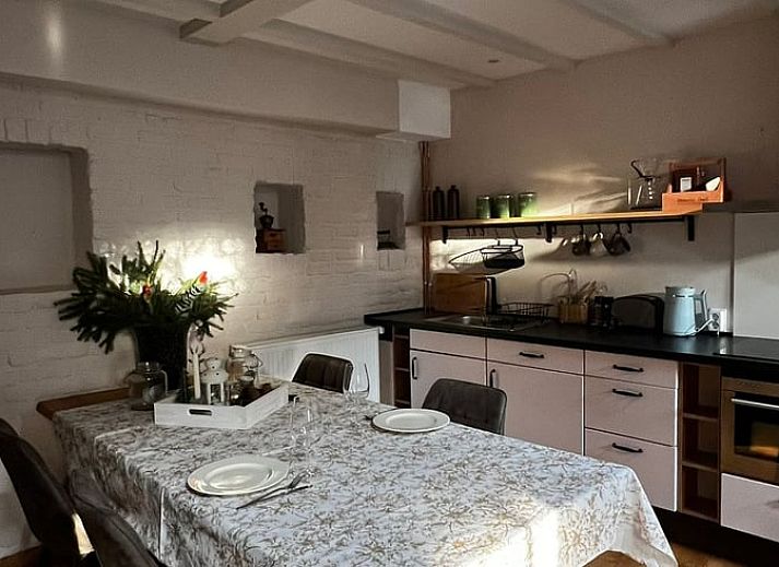 Charming entrance to a vacation home in Beutenaken, South Limburg, with a rustic brick wall and decorative plants.