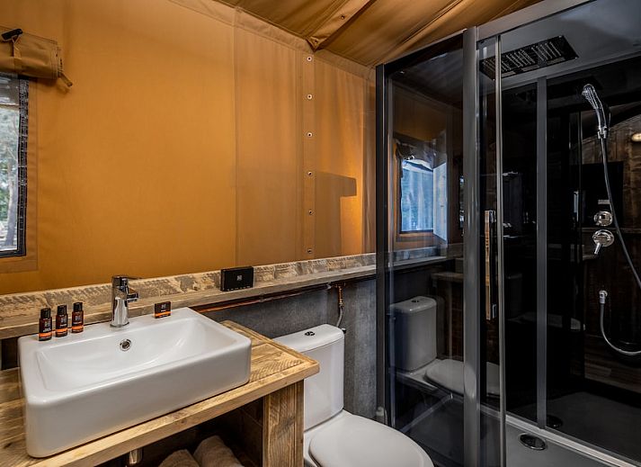 Binnenruimte van Safaritent 6A in Mierlo met een gezellige zithoek en eethoek, ideaal voor glamping in De Peel.