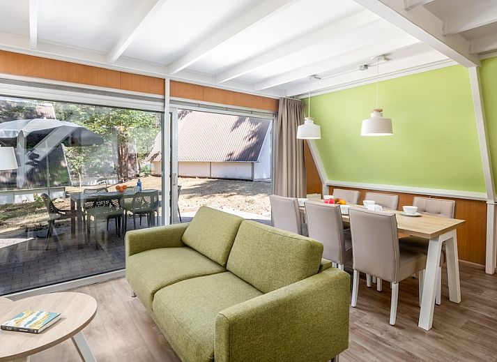 Gezellige woonkamer in W6A Comfort bungalow, Mierlo, De Peel, Noord Brabant met uitzicht op terras en natuur.