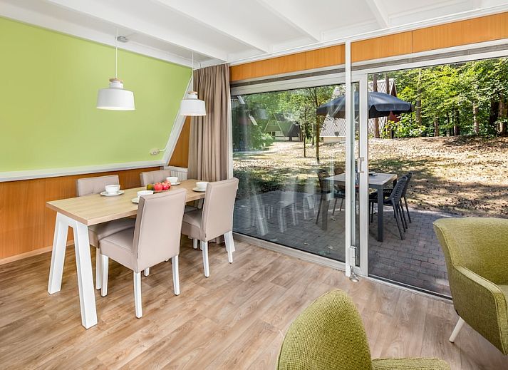 Cozy living room of W4A Comfort bungalow in Mierlo, De Peel, North Brabant, overlooking wooded area.