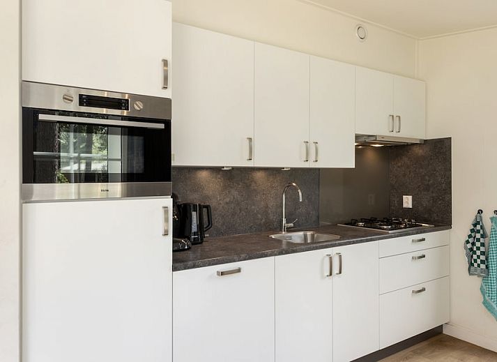 Cozy living room of Chalet 6 in Vlierden, De Peel, North Brabant with modern furnishings and views of the green surroundings.