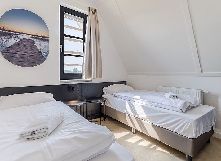 Gezellige woonkamer in 10-persoonsbungalow 10EL, Someren, met uitzicht op de natuur.