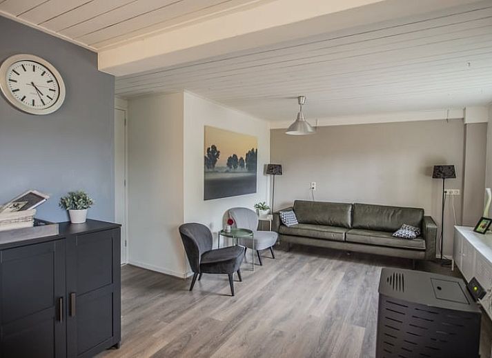 Rustige tuin bij Vakantiehuisje in Aarle-Rixtel, Noord Brabant, met groene omgeving en comfortabele stoelen.