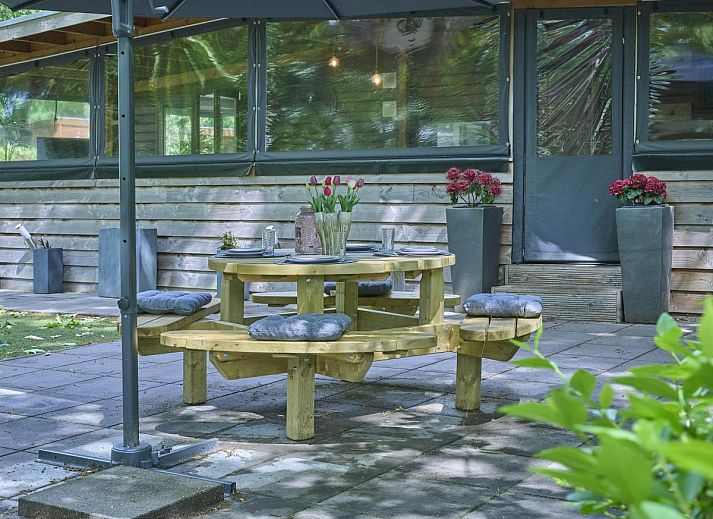 Gezellige binnenruimte van vakantiehuis 't Heische hofje in Zeeland, De Peel, Noord Brabant, met comfortabele zitplek en uitzicht op de natuur.