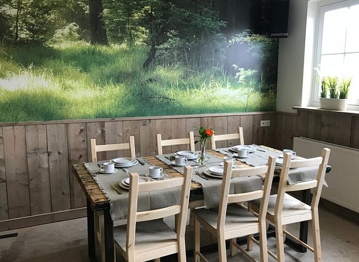 Ontspan op de veranda van Huisje in Baarle-Nassau, vakantiehuis in Noord Brabant, omringd door kleurrijke bloemen.