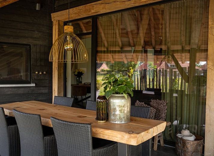 Rustieke buitenkant van Vakantiehuis in Baarle-Nassau met rieten dak en groene tuin in Noord Brabant.