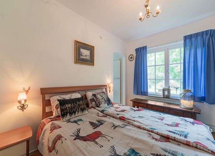 Rustiek terras bij Mc Ghil vakantiehuis in Baarle-Nassau, omringd door groene bomen.