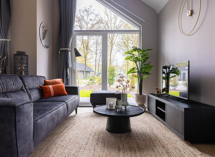 Modernes Wohnzimmer in Ecovilla Waterzicht, Ferienhaus in Oirschot, mit Blick auf den Garten in Kempen, Nordbrabant.