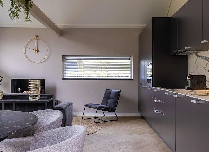 Modernes Wohnzimmer in Ecovilla Waterzicht, Ferienhaus in Oirschot, mit Blick auf den Garten in Kempen, Nordbrabant.