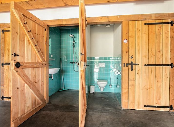 Gemuetliche Essecke im Cottage in Eersel, Ferienhaus in den Kempen, Nordbrabant, mit bunten Stuehlen und Holztisch.