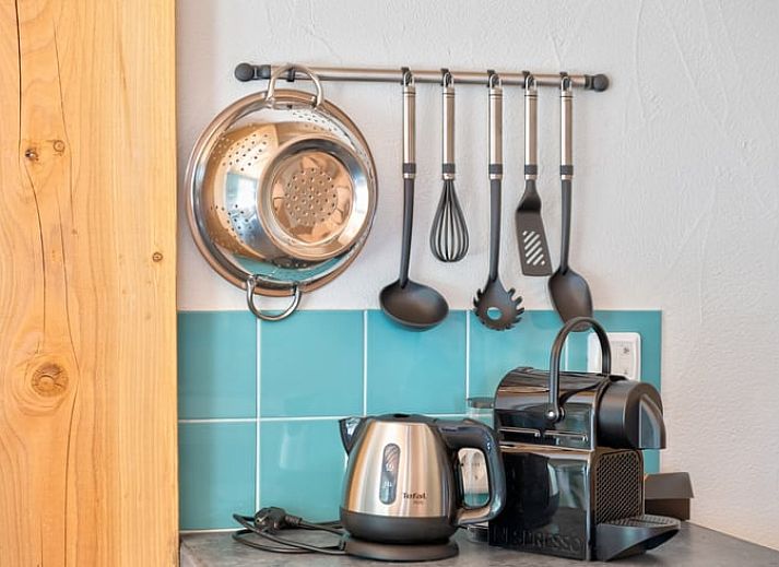 Gemuetliche Essecke im Cottage in Eersel, Ferienhaus in den Kempen, Nordbrabant, mit bunten Stuehlen und Holztisch.