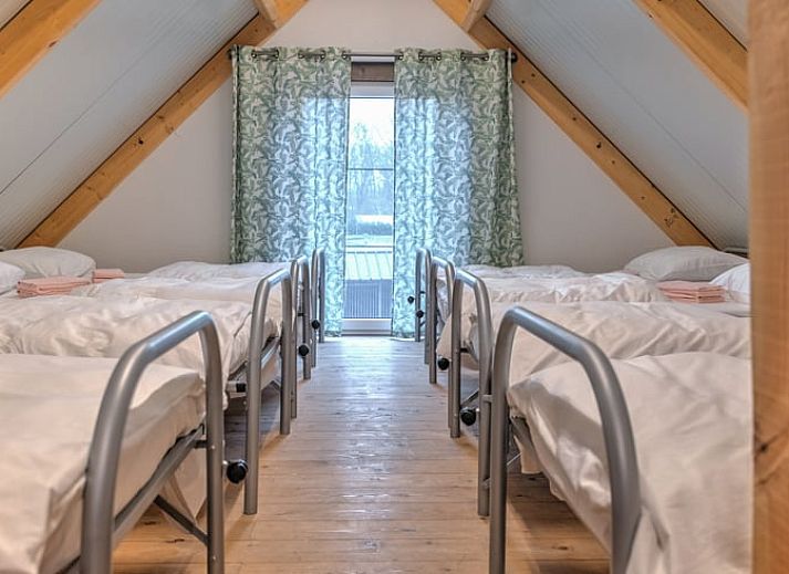 Gemuetliche Essecke im Cottage in Eersel, Ferienhaus in den Kempen, Nordbrabant, mit bunten Stuehlen und Holztisch.