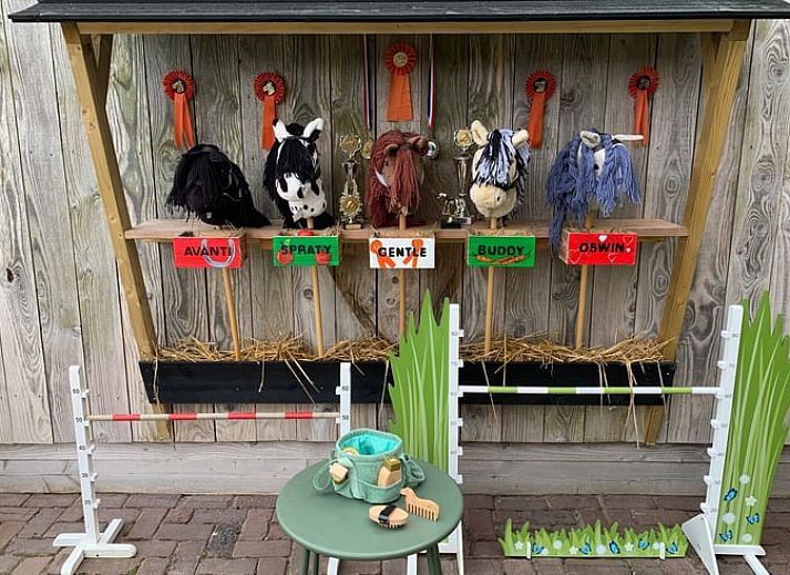 Kinder spielen im Garten von Huisje in Eersel, einem Ferienhaus in Eersel, Kempen, Nordbrabant.