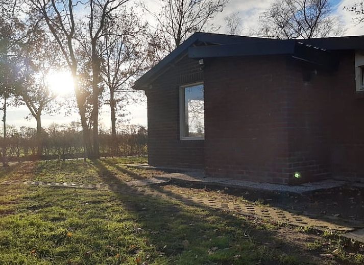 Sonnenuntergang durch das Fenster im Ferienhaus in Soerendonk, beruhigende Aussicht.