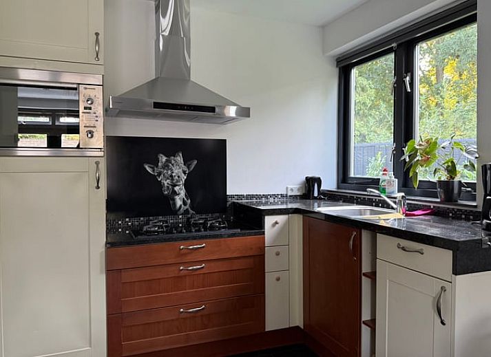 Gemuetliches Wohnzimmer in Cottage in Luyksgestel, Ferienhaus in Luyksgestel, mit bequemem Sofa und Essecke.