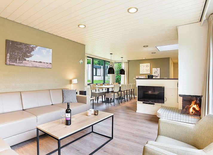 Gezellige woonkamer in Het Vennenbos 8-persoons bungalow 8C in Hapert, Kempen, Noord Brabant met open haard en ruime zithoek.