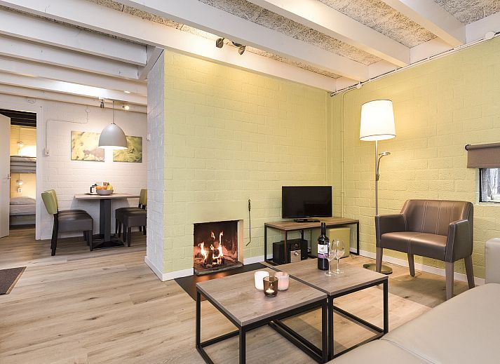 Gemuetliches Wohnzimmer im 5-Personen-Bungalow 5B1 in Het Vennenbos, Hapert, mit modernen Moebeln und Gartenblick.