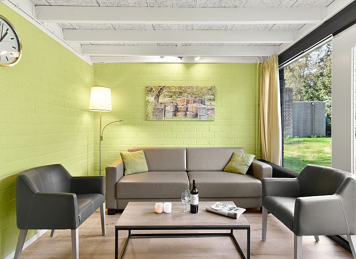 Gemuetliches Wohnzimmer im 5-Personen-Bungalow 5B1 in Het Vennenbos, Hapert, mit modernen Moebeln und Gartenblick.