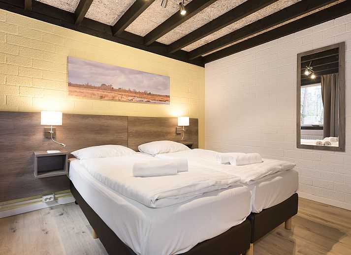 Blick auf die Terrasse vom Wohnzimmer des 5-Personen-Bungalows 5B1 von Het Vennenbos in Hapert, umgeben von Natur.