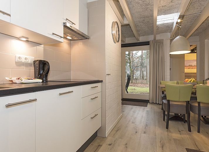 Entspannte Sitzecke im 5-Personen-Bungalow Het Vennenbos 5B1, Hapert, mit bequemem Sofa und dekorativen Details.